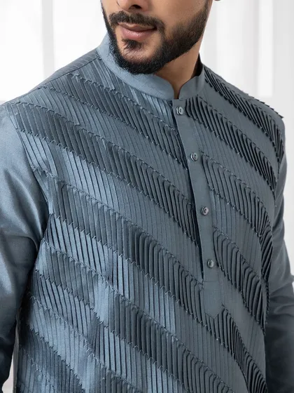 The texture of this deep grey kurta is its defining feature. The diagonal pintuck detailing creates a visually interesting and modern piece for evening events.