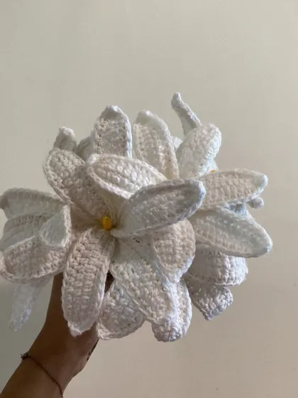 A closer look at the intricate details of the handmade white crochet lilies.