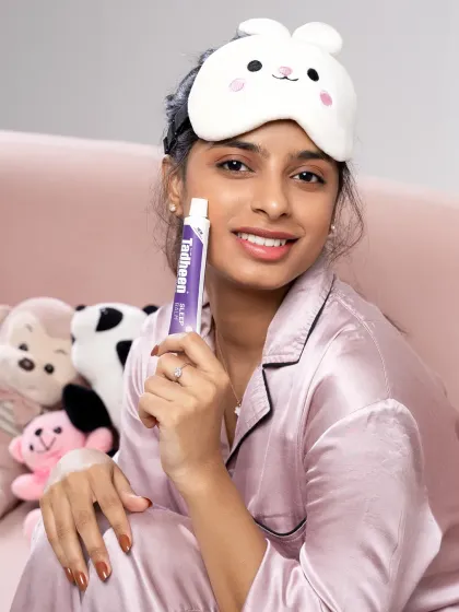 A bright and friendly product shot for Tadheen. The model holds the sleep balm while smiling at the camera, creating a trustworthy and inviting image for the brand.