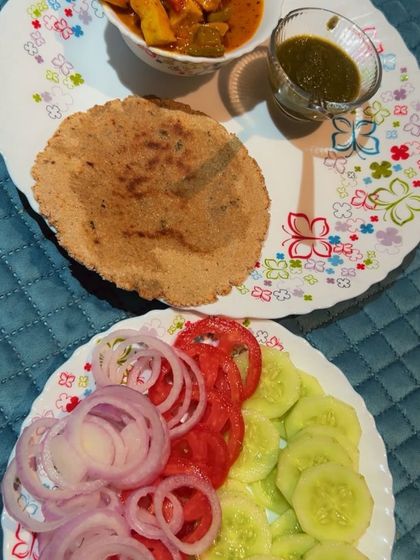 A traditional Indian thali with roti, paneer curry, and a fresh salad of onions, tomatoes, and cucumber. My plans incorporate the foods you love in a balanced way.