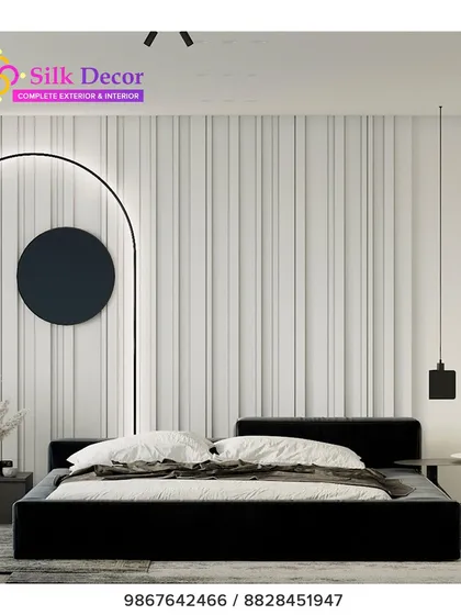 A bold, minimalist bedroom centered around our custom black platform bed. The stark, simple frame provides a strong anchor for the room, contrasting with the textured white wall and demonstrating our versatility in modern design styles.