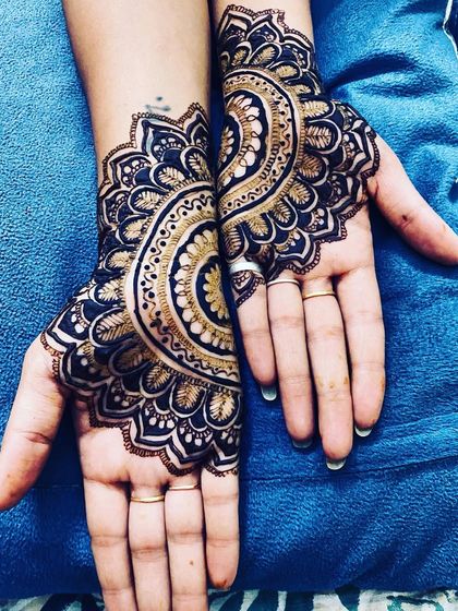 A stunning back-hand design featuring two large, symmetrical mandalas. The use of bold lines and negative space gives it a modern yet traditional feel.