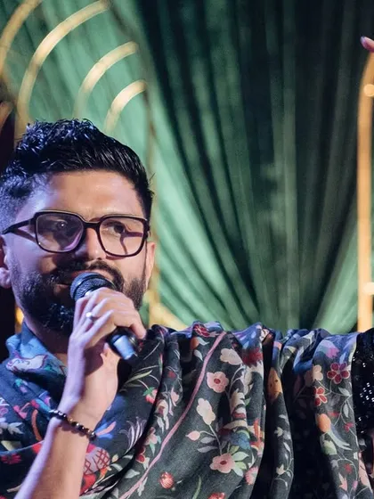 A close-up shot of me on stage, completely in my element, hosting a beautiful wedding celebration. The energy of the crowd and the happiness of the family is what I live for.
