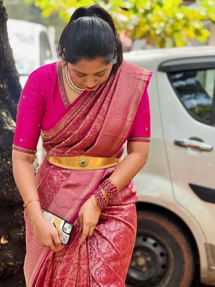 A client in a rich pink Kanchivaram saree, paired with a matching blouse for a classic, monochromatic look.