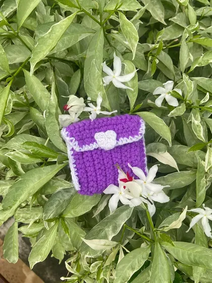 Another view of the purple coin pouch, showing how it looks against different flowers. You can pick any two colors for your own custom pouch.