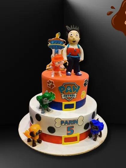 This two-tier Paw Patrol cake is ready for a ruff-ruff rescue. The design incorporates the show's logo and Dalmatian spots, surrounded by the brave pups for a fun-filled fifth birthday.