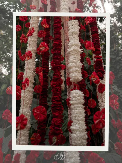 A stunning detail of hanging floral strings made from upcycled red fabric, which were used as a backdrop element. This shows how even small pieces of sentimental fabrics can be transformed into beautiful decor.