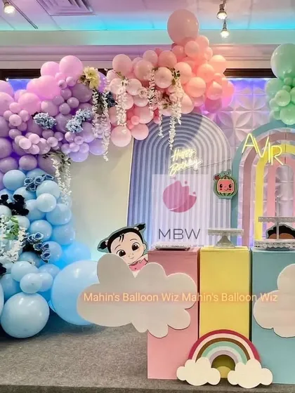This shot shows the beautiful, cascading pastel balloon garlands that frame the modern arched backdrops of the Cocomelon party.