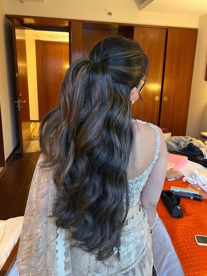 The back view of a simple yet elegant half updo with voluminous waves. This is a versatile look that works for any special occasion.