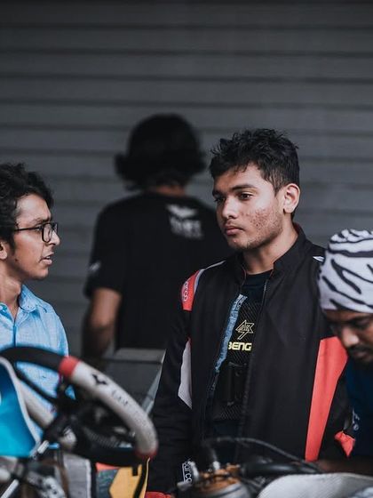 The team discussing strategy in the pits at the Rok Cup Singapore.