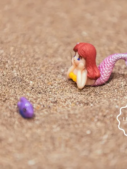 Another tiny mermaid figure waiting to be discovered in the sand.