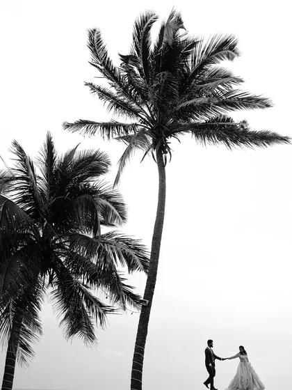 A dramatic black and white silhouette against the vastness of the sea and sky. This style of photography strips away color to focus on the form, connection, and emotion between the couple.