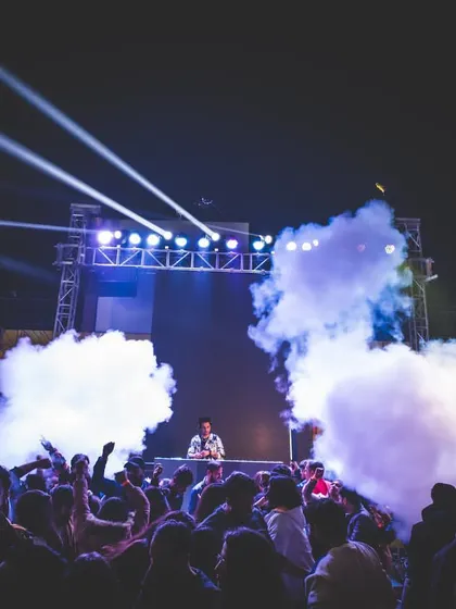 An outdoor venue in Delhi packed with people as the CO2 cannons create a massive cloud. This is the kind of high-impact moment I deliver.