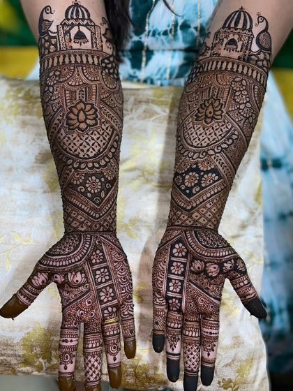 A grand design with palace architecture at the top, peacocks, and a central lotus motif on the arms.