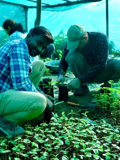 A participant in our nursery workshop smiles as he works with the seedlings, happy to be getting his hands dirty for a good cause.