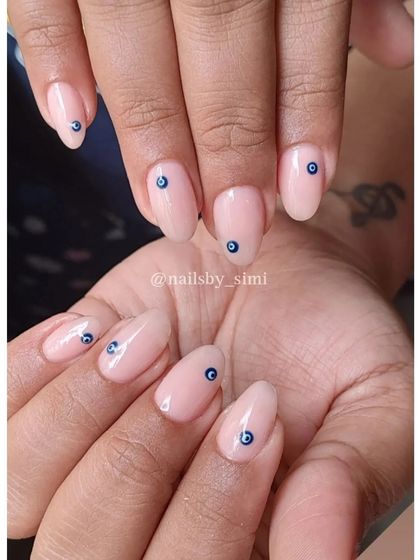 A simple and chic evil eye design. The delicate blue evil eye on a natural nude base is perfect for adding a touch of protection and style to your look.