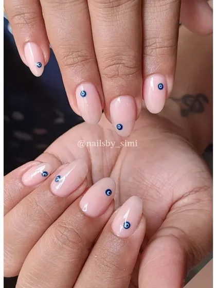 A simple evil eye design on a sheer nude base for a touch of protection and style.