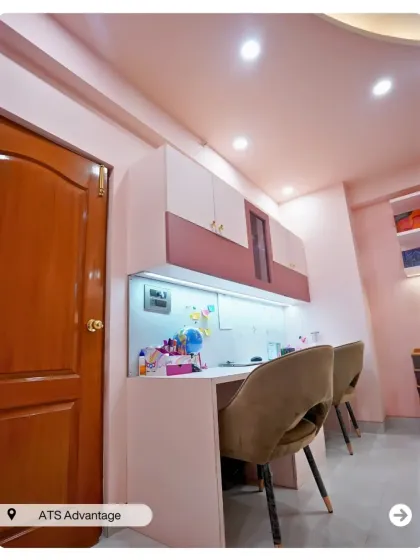 A practical and stylish study area for two. The design includes ample desk space, overhead cabinets for storage, and comfortable chairs, all in a soft, modern color palette.