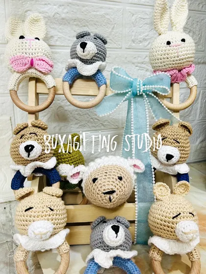 These handmade crochet rattles are crafted with soft yarn and a wooden ring, making them a safe and beautiful keepsake for any baby.