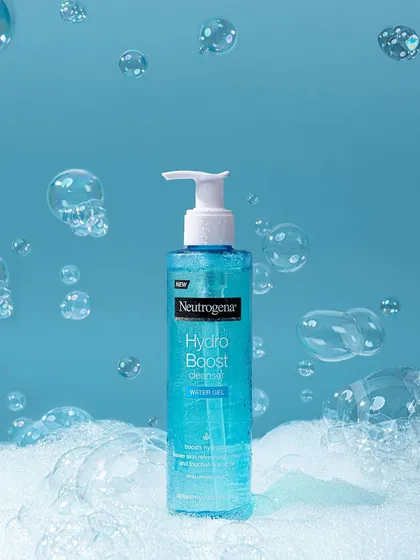 A conceptual shot for Neutrogena's Hydro Boost cleanser, using suspended bubbles against a clean blue backdrop. The styling creates a sense of weightlessness and deep, bubbly cleansing action.