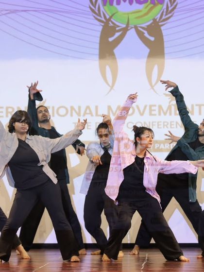 The full dance crew in a moment of synchronized expression. Performing together as a company is about creating a single, powerful narrative on stage through collective movement.
