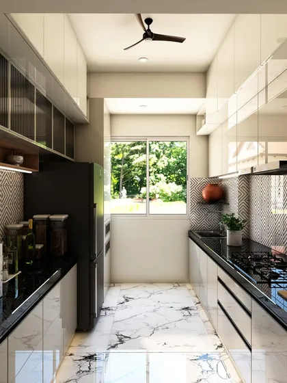 A full view of the galley kitchen, demonstrating how the reflective surfaces and light color palette make the narrow space feel brighter and more open.