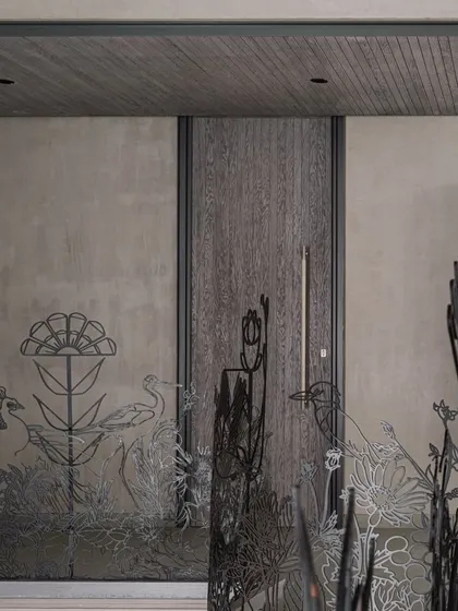 The metal railing seen in context with the home's entrance, showcasing how the organic, nature-inspired forms contrast with the clean lines of the modern architecture and wooden door.