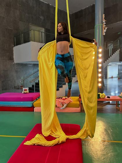A beautiful, flowing pose where the aerialist uses the fabric to create elegant shapes. Our classes blend athletic skill with creative expression.