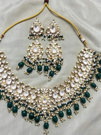 A high-quality Kundan necklace set with dark green beads. This rental set includes a wide necklace and matching earrings, perfect for a reception or wedding.