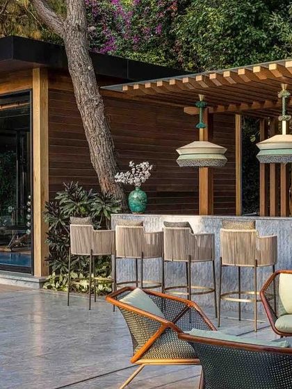 A daytime view of the outdoor bar, showcasing the natural materials and comfortable seating that make it an inviting spot for social gatherings.