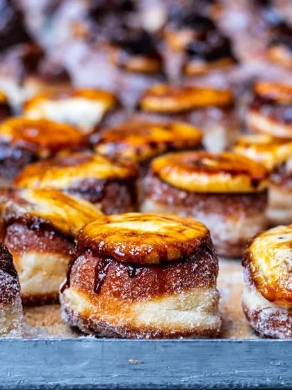 A tray full of crème brûlée donuts. This shot shows the product in quantity, which is great for wholesale catalogues or illustrating the scale of a bakery's production.