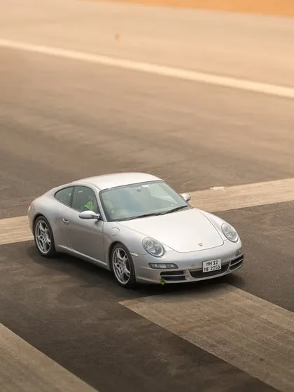 A minimalist shot focusing on the clean design of a Porsche 911, using the runway markings to create a strong compositional frame.