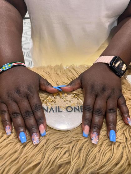 A final shot of the stylish blue French manicure with floral and glitter details.