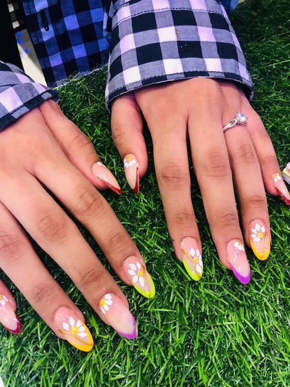 A great shot of the colorful daisy nails on a background of green grass.