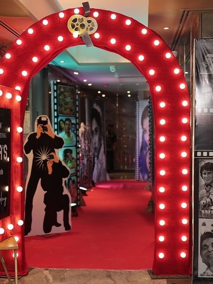 This 70s retro party entrance combined a lit-up arch, a red carpet, and themed props like a guitar cutout to create a complete visual story. I ensure every element works together to build a cohesive atmosphere for your event.