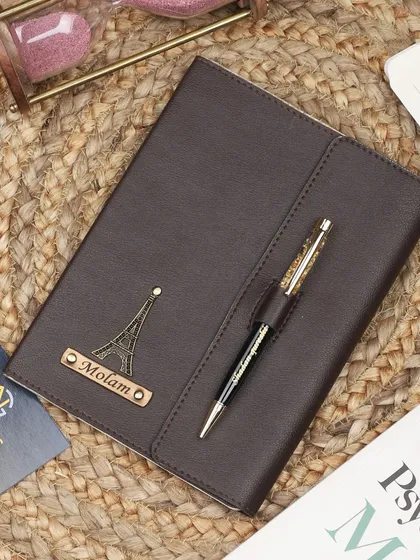 A personalized brown diary with a magnetic flap, customized with an Eiffel Tower charm for the travel lover.