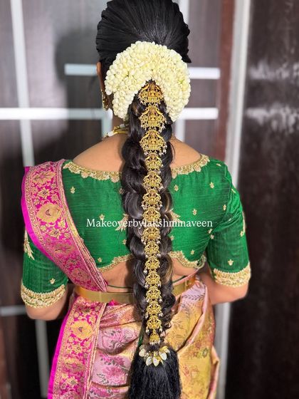 The back view of this traditional half-saree look, showing the intricate bridal braid adorned with temple jewelry.