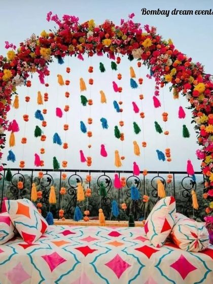 A closer look at the vibrant floral and tassel arch, perfect for a colorful outdoor Mehndi ceremony.