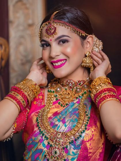 A happy, smiling close-up that highlights the vibrant makeup and the intricate details of the jewellery.