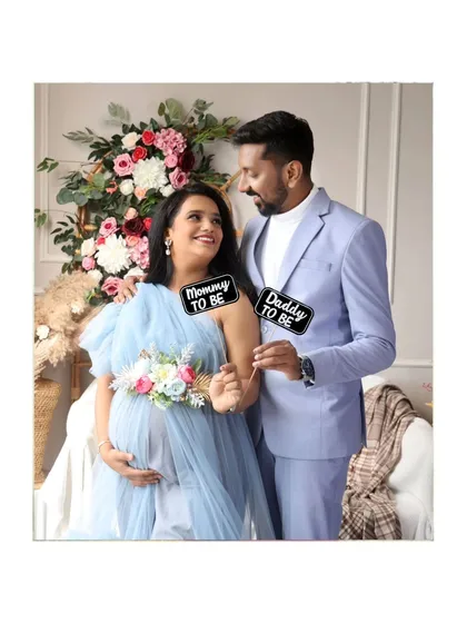 A sweet couple's portrait with "Mommy to be" and "Daddy to be" props. Their joy is evident in this lovely boho setup.