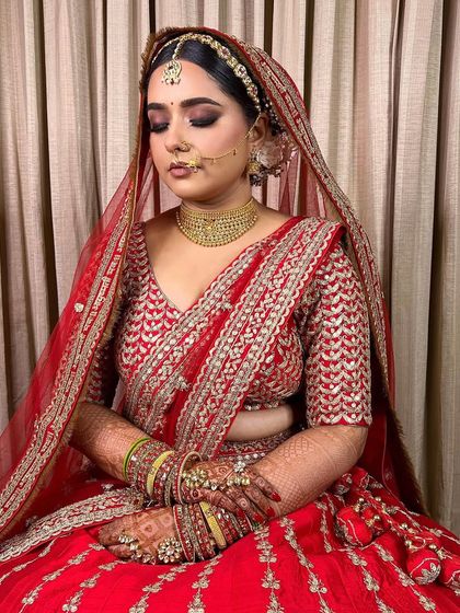 A moment of calm before the ceremony. This bride's makeup features beautifully blended smokey eyes and a flawless base, creating a look of serene elegance.