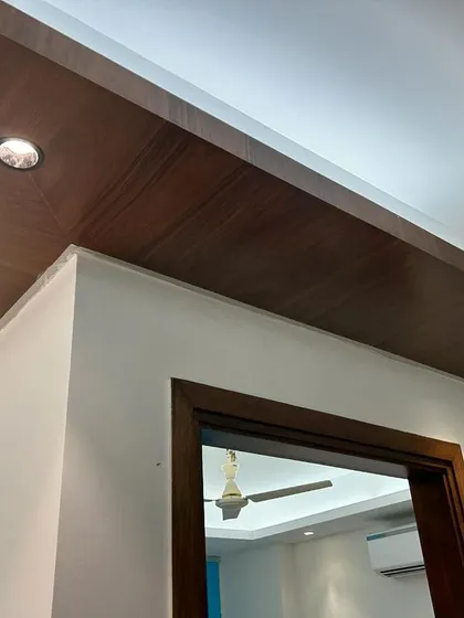 A close-up of the ceiling detail in the CR Park project. We installed a wooden panel to add a warm, decorative element and fitted it with spotlights for focused lighting.