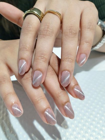 A beautiful example of cat-eye nail art on almond-shaped nails, creating a diagonal shimmer effect that is both subtle and eye-catching.
