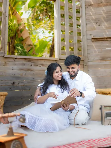 A sweet moment of a couple looking through a photo album together in a cozy, rustic cabin set, perfect for telling the story of their journey.