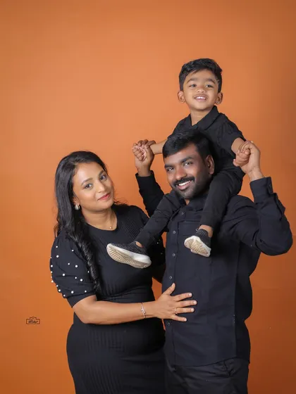 A fun family portrait with a little boy enjoying a shoulder ride from his dad. This studio shot shows the playful and happy dynamics of this family of three.