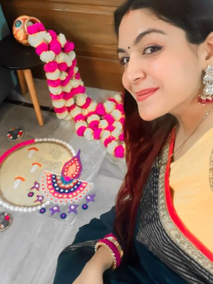 A festive selfie with my Diwali decorations. The red jhumkas and bangles perfectly complement the yellow and red border of my saree.