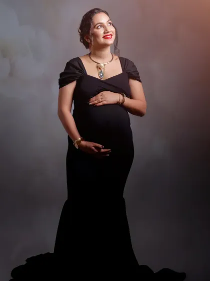 A hopeful and radiant portrait of the mother-to-be, looking up towards the light. The simple styling emphasizes her natural pregnancy glow.