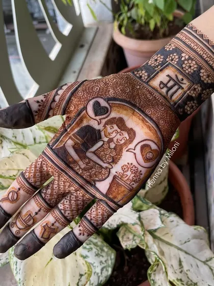 A close-up of a baby shower mehendi. This design features a loving portrait of the parents-to-be, with the word "Maa" (Mother) on the wrist.