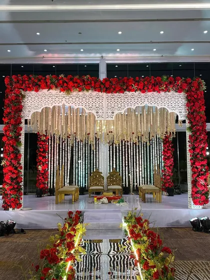 We believe in the timeless power of tradition. This magnificent mandap, framed by a rich arch of red roses and adorned with delicate white floral strings, creates a sacred and visually stunning space for wedding vows.