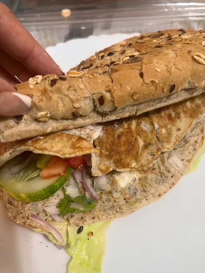 This is my idea of a perfect Sunday meal. A multigrain sandwich filled with a fluffy omelette, fresh lettuce, cucumber, tomato, and onion. It proves that a balanced breakfast is the first step to a balanced life.